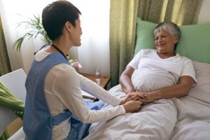 Female nurse taking care of senior female patient at retirement home